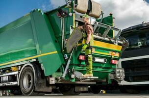 Caucasian Modern Garbage Truck Worker and the Vehicle. photo