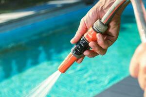 Hand Holding Garden Hose Nozzle with Water On photo