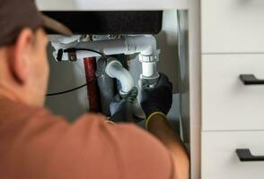 Professional Plumber Installing New Sink Drainage photo