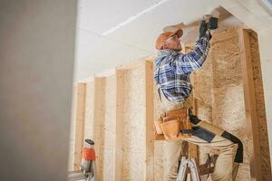 Worker Attaching Drywall photo
