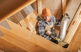Technician Installing Home Ventilation Elements photo