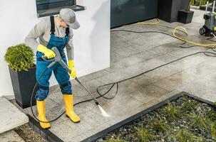 Men Pressure Washing His House Surrounding photo