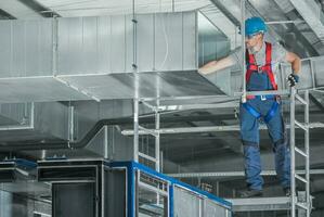 Installing HVAC System Air Circulation Duct Inside a Warehouse photo