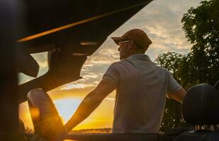 hombres detener en lado de el la carretera a disfrutar escénico puesta de sol foto