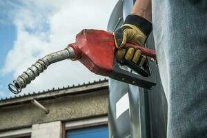 Men Hold Diesel Pump Nozzle in His Hand photo