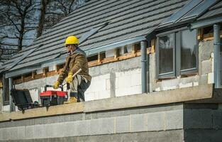 European Residential Construction and Worker with His Toolboxes photo