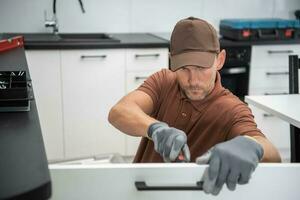 Pro Cabinetmaker Installing New Kitchen Furnitures photo