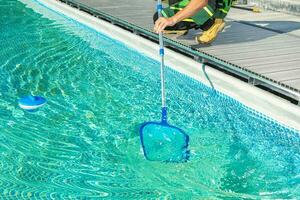 Cleaning Swimming Pool with Skimmer Net photo