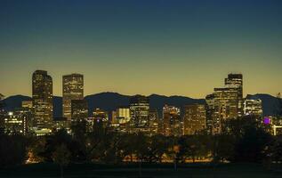 Illuminated Denver Downtown Towers and Front Range Mountains in a Background photo