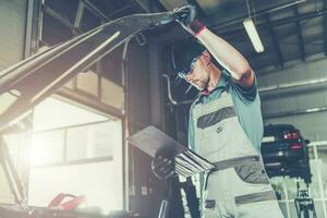 Caucasian Car Mechanic Electronic Elements Technician Checking on an Issue photo