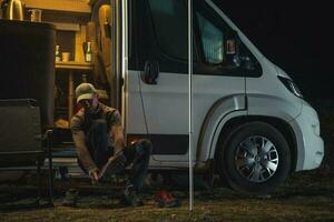 Hiker Changing Shoes in Front of His Camper Van photo