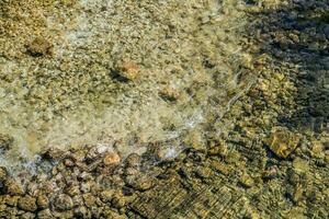 rocoso río cama con cristal claro agua. foto