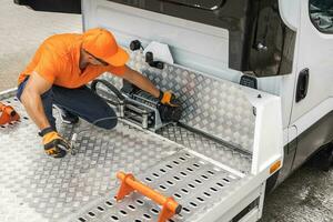 Men Preparing Towing Truck For Repossession Work photo