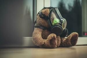 juguete osito de peluche oso con protector máscara por el ventana. foto