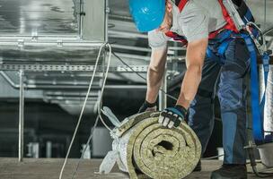 Worker with Piece of Mineral Wool Insulation photo