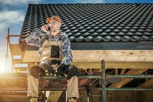 construcción trabajador en teléfono llamada descanso a edificio sitio foto