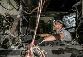 Mechanic Inside RV Coach Bus Diesel Engine Compartment photo