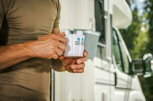 Men Staying with Cup of Hot Tea in Front of His Camper Van photo