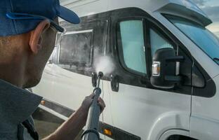 Men Washing RV Camper Van Using Pressure Washer photo