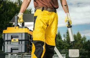 Construction Worker with Silicon and Tools Box in His Hands photo