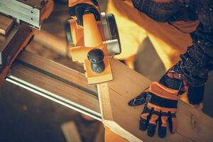 Construction Carpenter with Wood Planer in Action photo