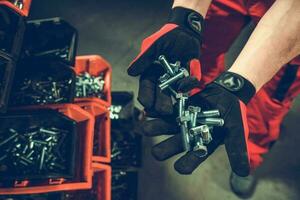 Worker with Bunch of Metal Bolts in His Hands photo