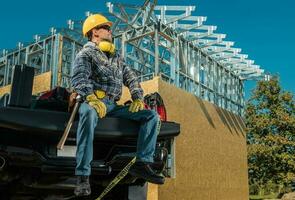 Proud Contractor in Front of Residential Building Skeleton photo