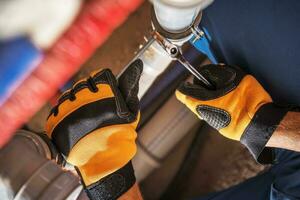 Plumber Worker Adjusting Water and Sewage System Elements photo