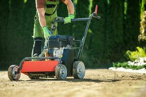 Landscaper Pushing Lawn Aerator photo