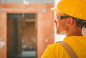 Yellow Uniform and Hard Hat Wearing Construction Worker photo