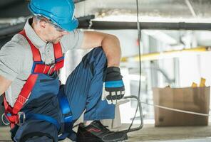 Caucasian Industrial Worker Wearing Safety Harness photo