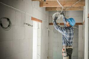 Worker Installing Electrical Cables Line photo