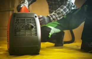 Construction Worker Preparing Gasoline Electricity Generator To Work photo