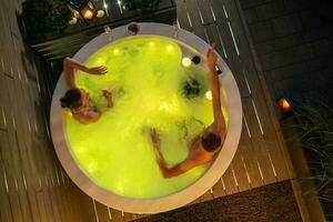 Couple Enjoying Their Time in the Outdoor Garden Hot Tub SPA photo