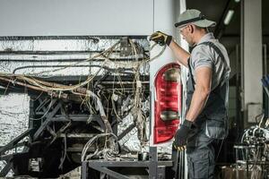 Bus Service Technician Staying in Front of Vehicle With No Diesel Engine Inside photo