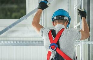 Construction Worker Climbing on Aluminium Scaffolding photo