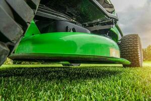 Backyard Garden Field Mowing Using Riding Tractor Grass Mower photo