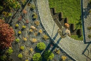 nuevo residencial jardín desarrollando por caucásico paisajismo trabajador foto