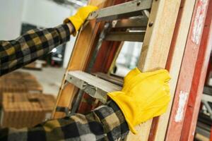 Construction Worker Moving Ladders on a Site photo