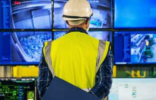 Engineer in Front of Facility Control Room Displays photo