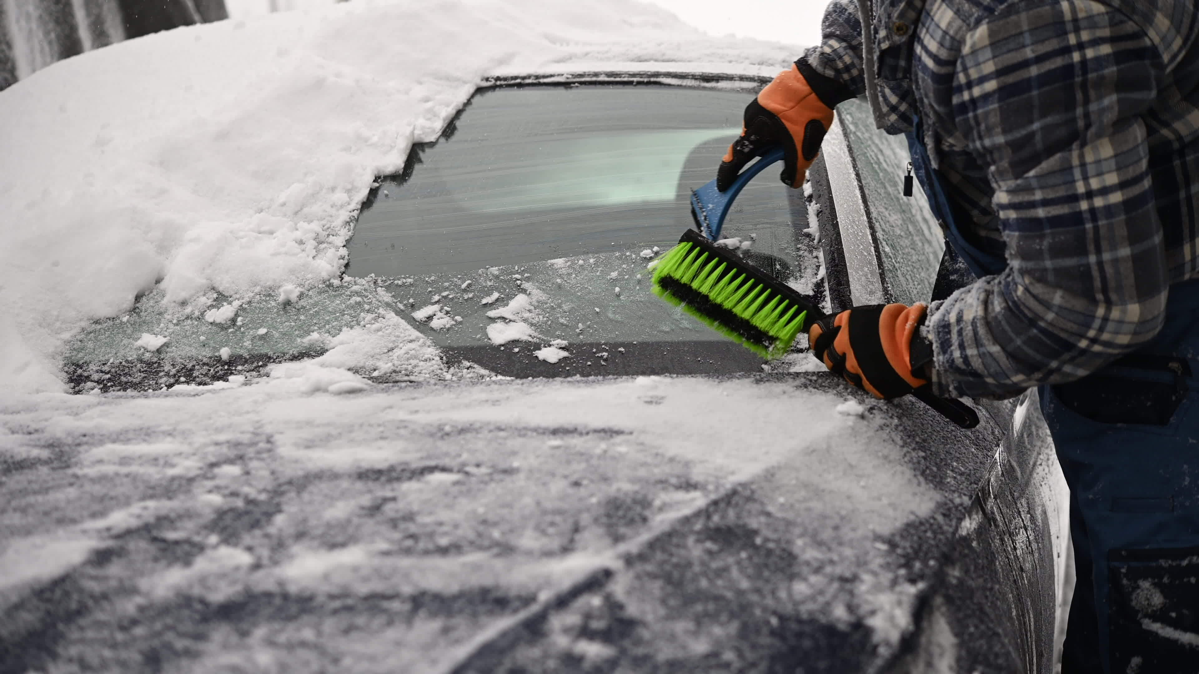 Treiber entfernen Schnee und Eis von seine Auto Windschutzscheibe 24629612  Stock-Photo bei Vecteezy