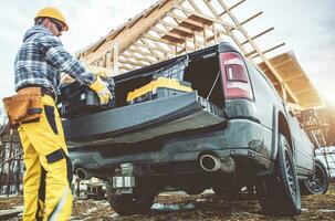 construcción trabajador tomando herramientas cajas desde su recoger camión foto