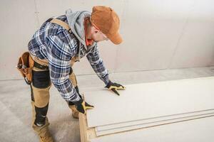 Male Construction Contractor Prepares Sheetrock Installation. photo