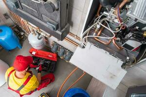 Residential Heating Systems Technician Performing Maintenance photo