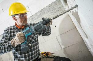 construcción trabajador con poderoso martillo perforar foto