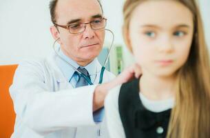 médico examinando pequeño niña foto