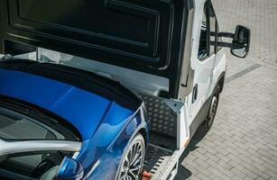 Blue Car Towed Away on a Towing Truck photo