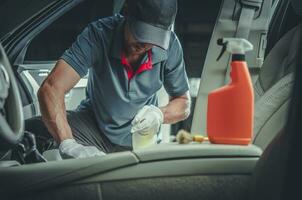 Caucasian Car Detailer Cleaning Modern Vehicle Interior photo