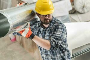 Construction Worker Moving Pieces of HVAC System photo