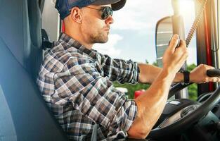 Commercial Trucker Driver Behind the Truck Wheel Talking Over Radio photo